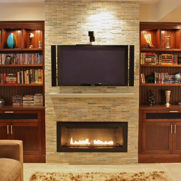 Cherry built ins for a basement entertainment room include illuminated niches for a warm and attractive display